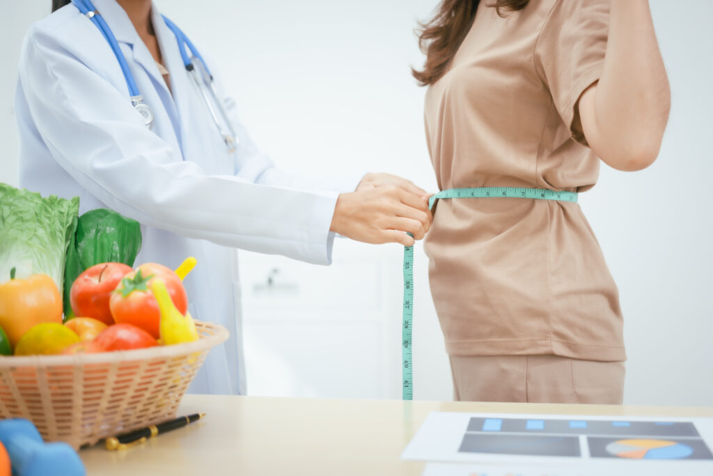 A young female nutritionist expert works at hospital desk,consulting female patients about eating