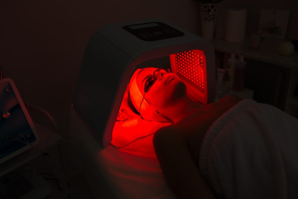 Woman having Ultraviolet LED light facial treatment at beauty salon